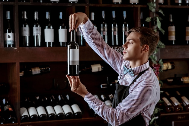 Knappe jonge sommelier bij de wijnwinkel