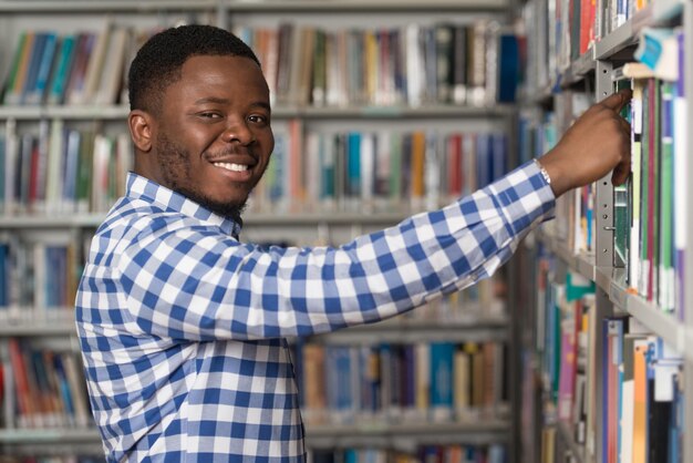 Knappe jonge student in een bibliotheek