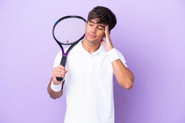 Knappe jonge tennisser man geïsoleerd op oker achtergrond met hoofdpijn