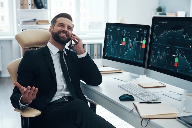 Knappe jonge zakenman die aan het bureau werkt