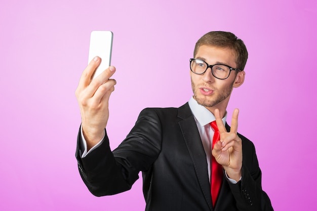 Knappe jonge zakenman die een selfie met een mobiele telefoon