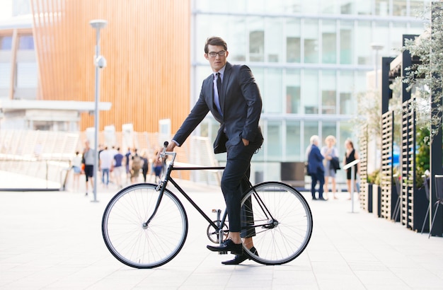 Knappe jonge zakenman met zijn moderne fiets.