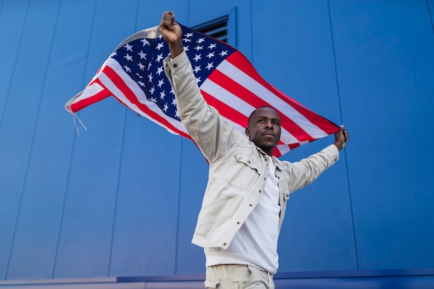 Knappe jonge zwarte man met de amerikaanse vlag op zijn hoofd ter gelegenheid van 4 juli