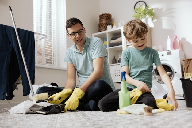 Foto knappe jongeman die het dansvloerconcept afveegt van het schoonmaken van het huis en het runnen van het huisinterieur