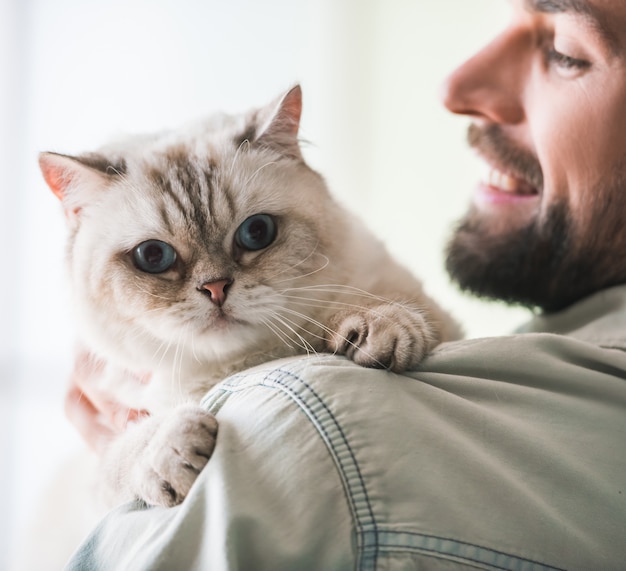 Knappe jongeman houdt een schattige kat.