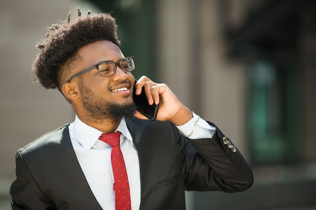 knappe jongeman in pak en bril met telefoon