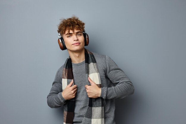 Knappe jongen elegante stijl geruite sjaal hoofdtelefoon geïsoleerde achtergrond