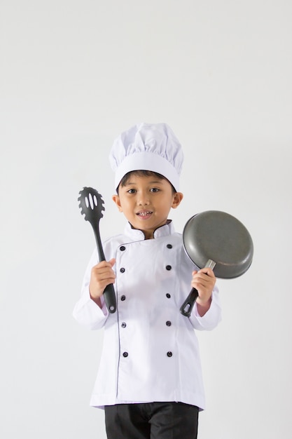 Knappe jongen in chef-kok eenvormig op geïsoleerd wit