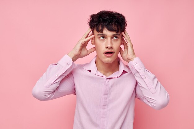 Knappe jongen in een roze shirt gebaren met zijn handen geïsoleerde achtergrond ongewijzigd