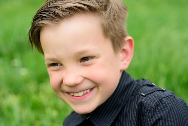 Knappe jongen in zwart t-shirt buiten. gelukkig kind emotie expressie. emotioneel kinderportret.