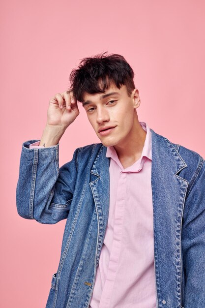 Knappe jongen mode kapsel poseren kleding denim jasje moderne stijl roze achtergrond ongewijzigd