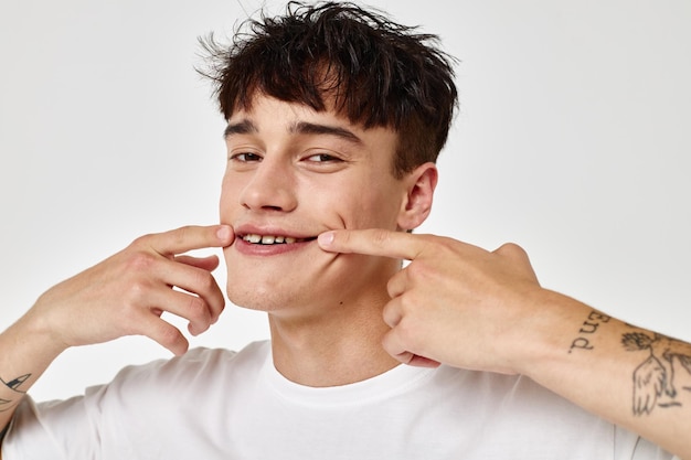 Knappe jongen moderne jeugd stijl witte t-shirt tatoeage op de arm model studio