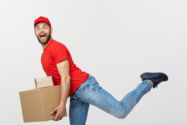 Knappe Kaukasische levering man haasten lopen voor het leveren van een pakket voor de klant.