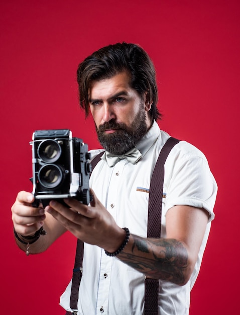 Knappe kerel hipster met snor en baard die foto maakt op vintage camera fotograferen