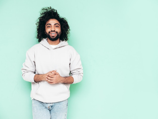 Knappe lachende hipster man poseren in studio