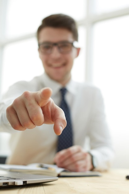 Knappe lachende zakenman die zijn vinger naar jou wijst