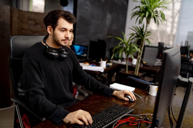 Knappe man aan het werk in casual doek op de computer Jonge kantoormanager aan het werk op de computer