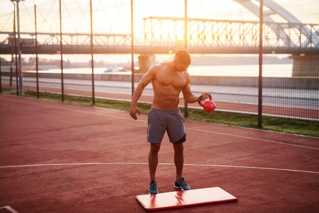 Knappe man aan het werk in de vroege ochtend met zonsopgang. Fitness training buitenshuis.