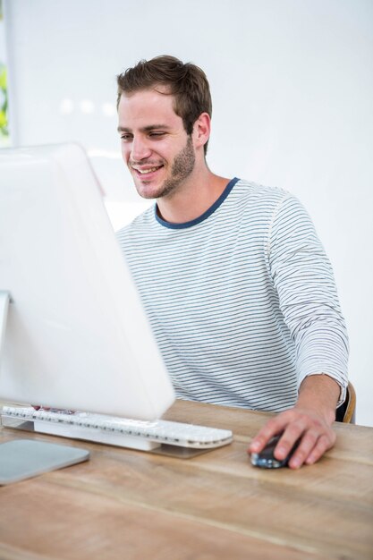 Knappe man aan het werk op computer in een heldere kantoor