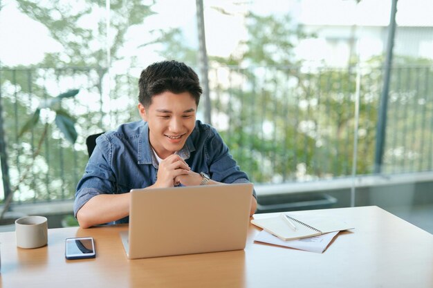 Knappe man Bebaarde knappe man die de ochtend in de woonkamer doorbrengt en videochat heeft