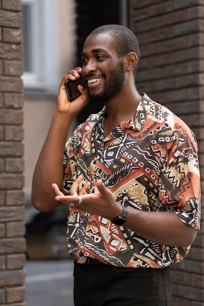 Foto knappe man die buiten aan de telefoon praat