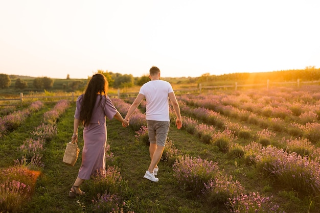 Knappe man die mooie vrouw zacht omhelst met picknickmand die weekend buitenshuis concept doorbrengt