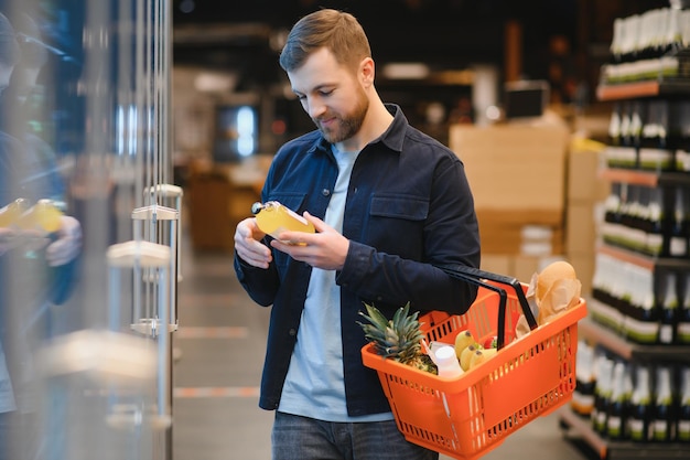 Knappe man die wat gezond eten en drinken koopt in een moderne supermarkt of kruidenierswinkel Lifestyle en consumentisme concept