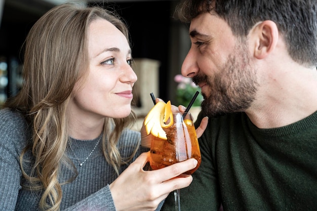 Knappe man en jonge vrouw die lacht op happy hour in cocktailbar Jonge geliefden koppel aan begin van liefdesverhaal Vriend en vriendin die samen rondhangen genieten van na het werk mooie drankjes