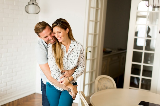 Knappe man en zwangere vrouw in de woonkamer