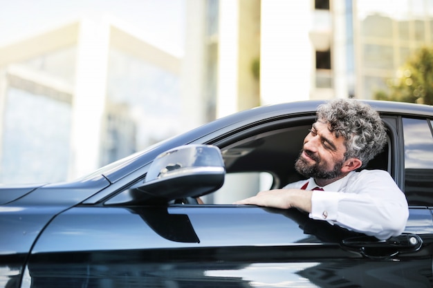 Knappe man in een auto in de stad