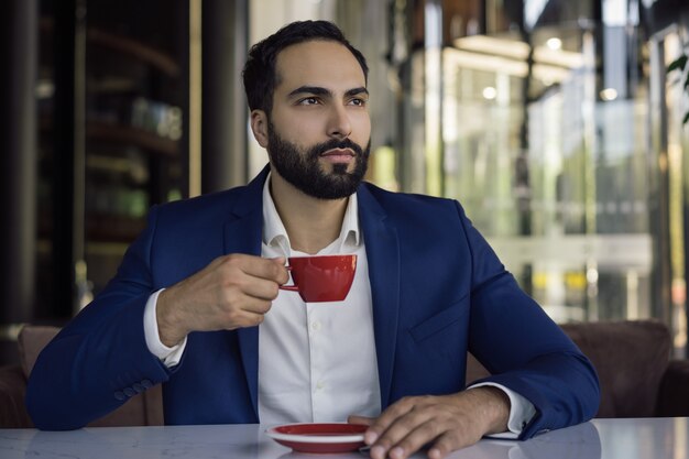 Knappe man koffie drinken in café