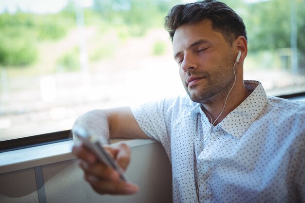 Knappe man luisteren muziek op mobiele telefoon