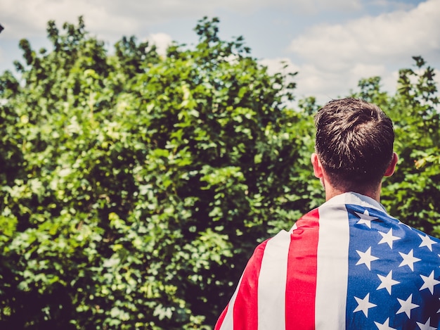 Knappe man met Amerikaanse vlag in zijn handen