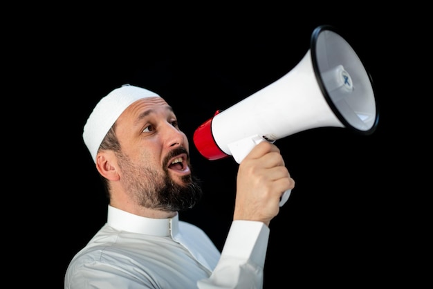 Knappe man met baard die door megafoon schreeuwt voor hadj in mekkah