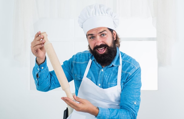 Knappe man met baard en snor die voedsel kookt