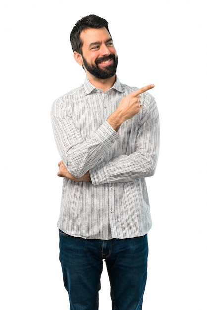 Knappe man met baard wijzende vinger aan de zijkant en de presentatie van een product