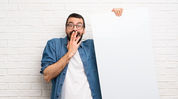 Knappe man met baard witte bakstenen muur met een leeg bordje