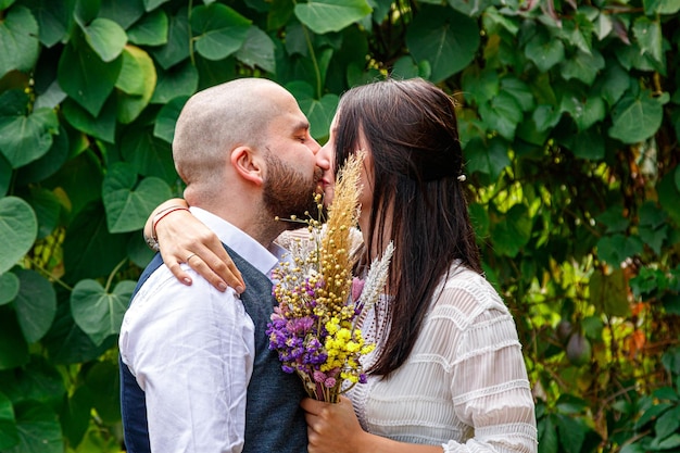 Knappe man met bloemen kust zijn verloofde