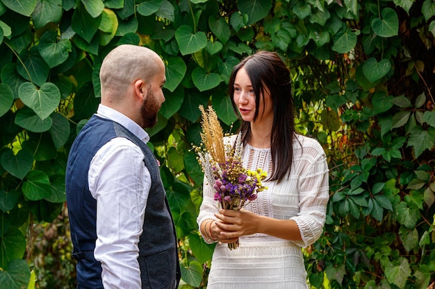 Knappe man met bloemen kust zijn verloofde