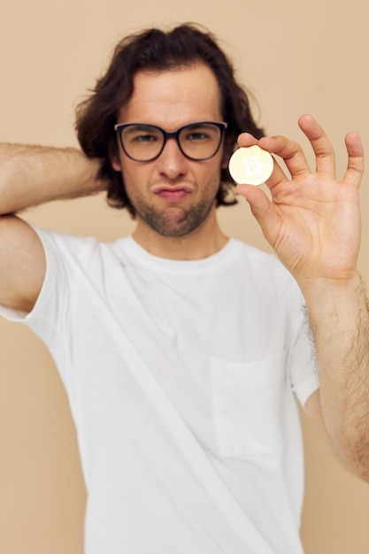 Knappe man met bril gouden bitcoin in handen geïsoleerde achtergrond