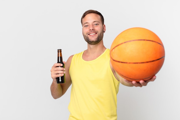 Knappe man met een biertje en een basketbalbal. een overwinning vieren