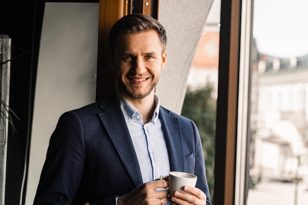 Knappe man met kopje koffie in café. Ochtend levensstijl van man.