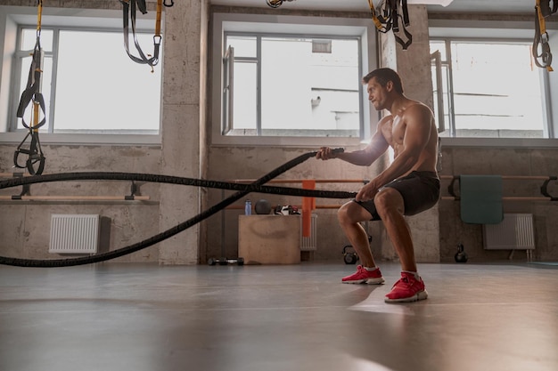 Knappe man met perfecte lichaamstraining in de sportschool