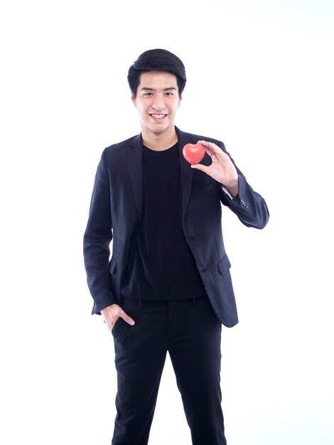 Knappe man met rood plastic hart op wit. Valentijnsdag concept