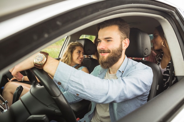 Knappe man met zijn vrienden reizen in de auto