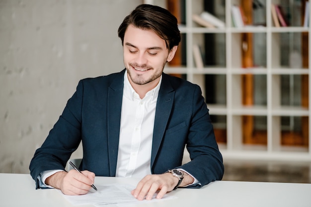 Knappe man ondertekening contract in het kantoor