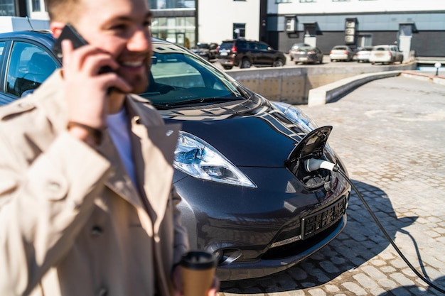 Knappe man praat aan de telefoon en drinkt koffie