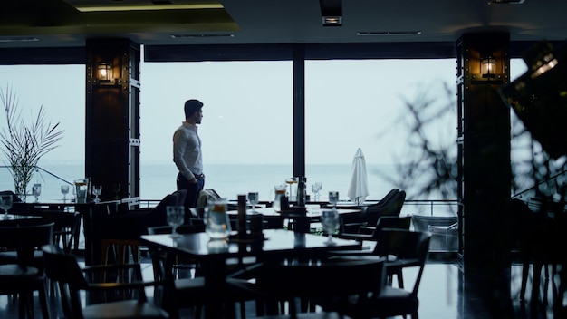 Knappe man silhouet tijd doorbrengen in klassiek donker café gastenhal interieur