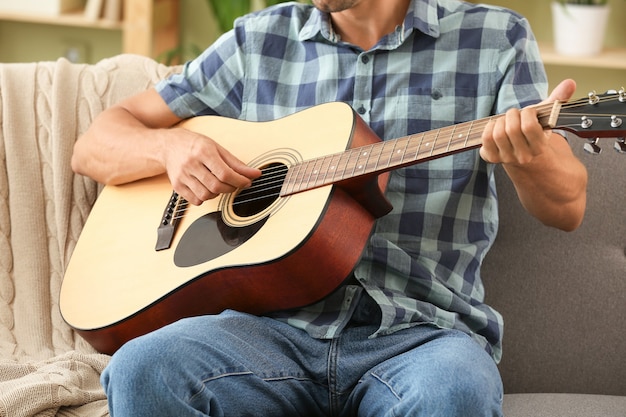 Knappe man thuis gitaarspelen