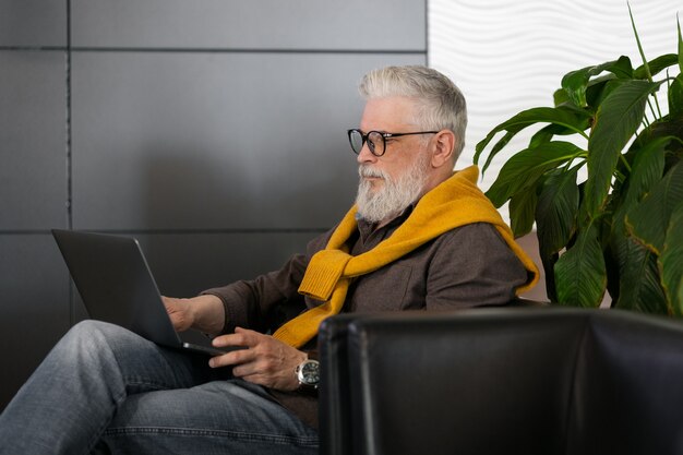 Knappe man van jaar oud met grijs haar die op een laptop werkt of online chat via videoconferenties